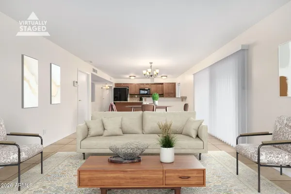 a big room with chandelier fan and kitchen view