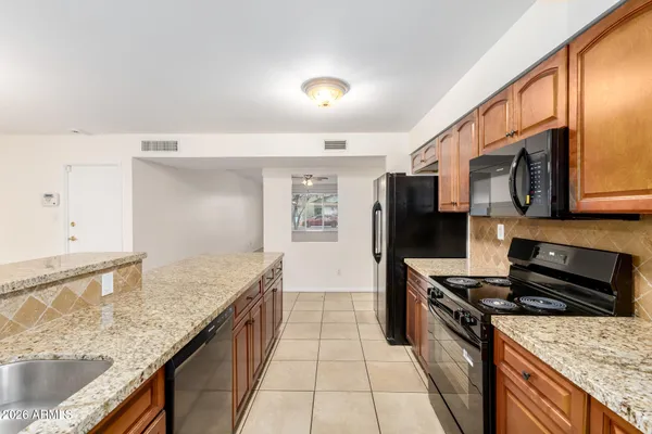 a kitchen with stainless steel appliances granite countertop a stove a sink and a microwave