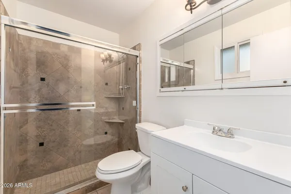 an empty room with wooden floor and ceiling fan