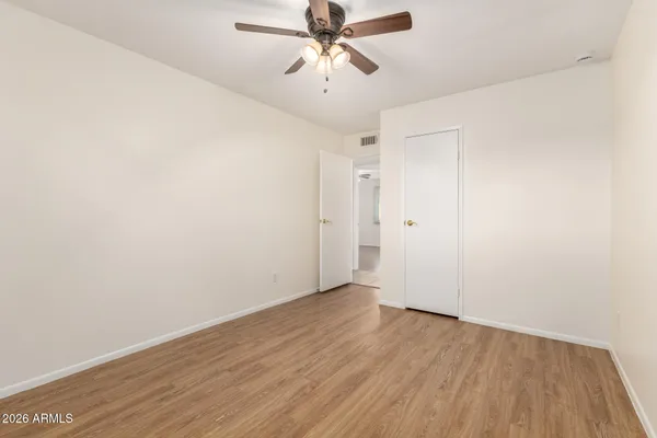 an empty room with a fan and a window