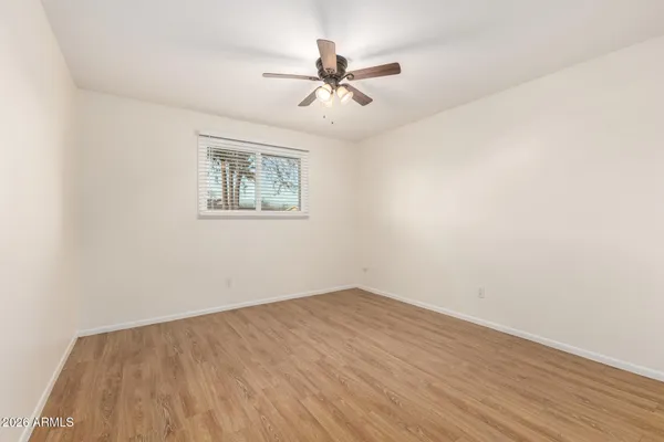 a view of a room with wooden floor and a ceiling fan