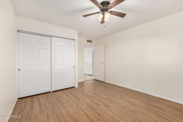 an empty room with a window and a ceiling fan