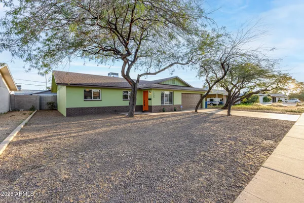 a view of a house with a tree in front of it