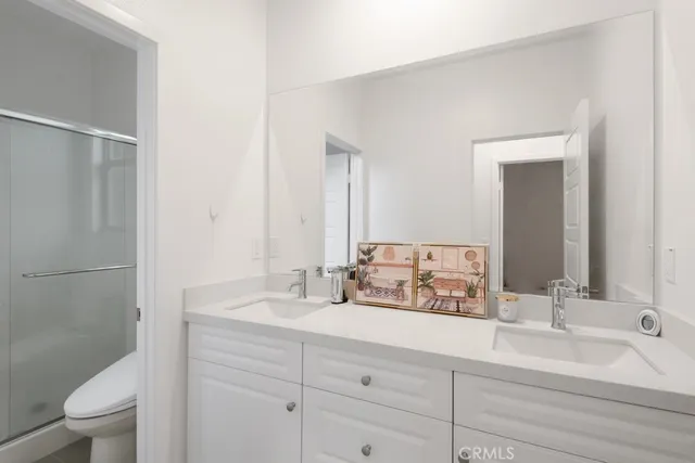 a bathroom with a double vanity sink mirror and toilet