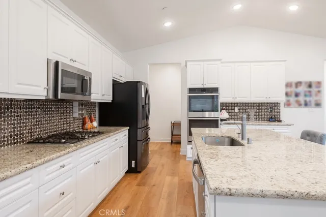 a kitchen with stainless steel appliances granite countertop a refrigerator stove and sink