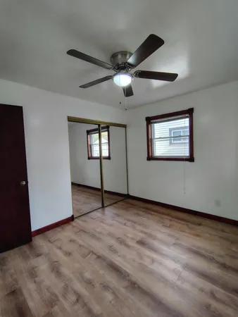 a view of an empty room with window and wooden floor