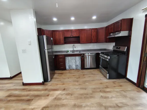 a kitchen with stainless steel appliances granite countertop a stove a sink and a refrigerator