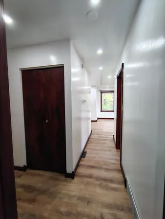 a view of a hallway with wooden floor and staircase