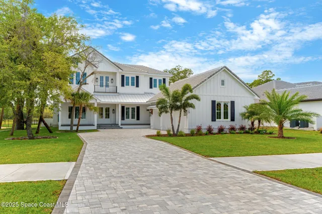 a front view of a house with a yard and trees