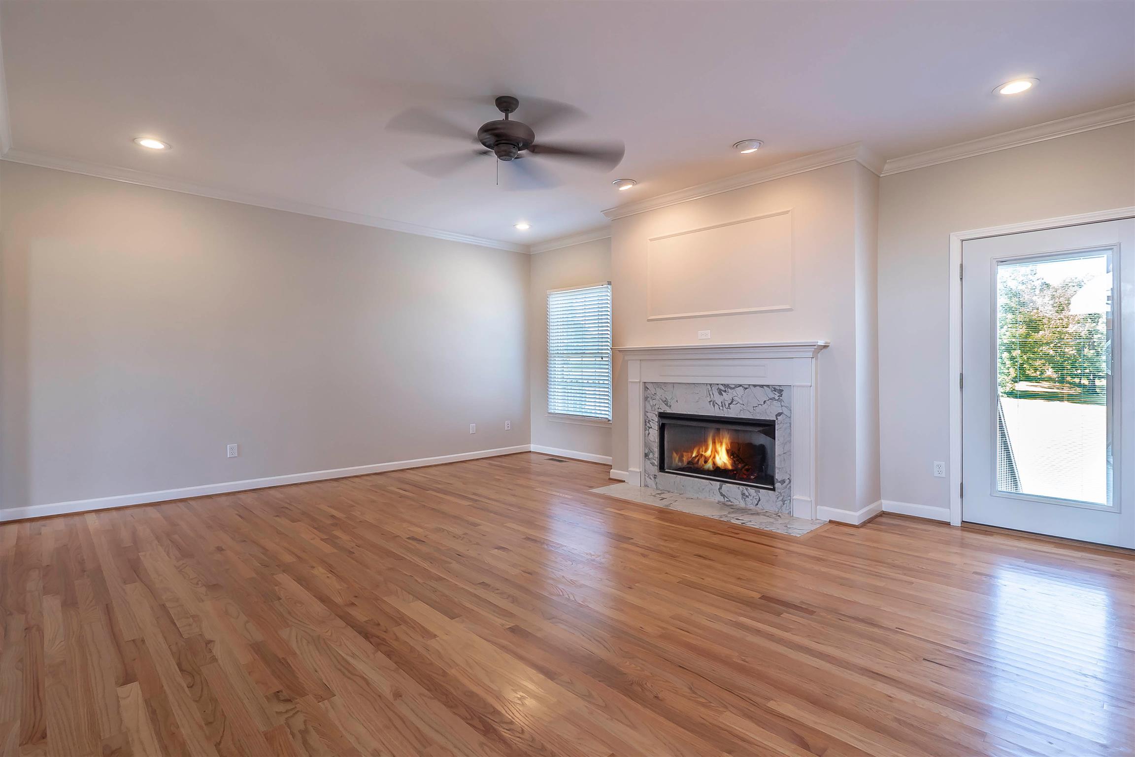 7722 Barnhill Road Primm Springs, TN 38476 - Photo 14 of 30 a view of an empty room with wooden floor fireplace and a window