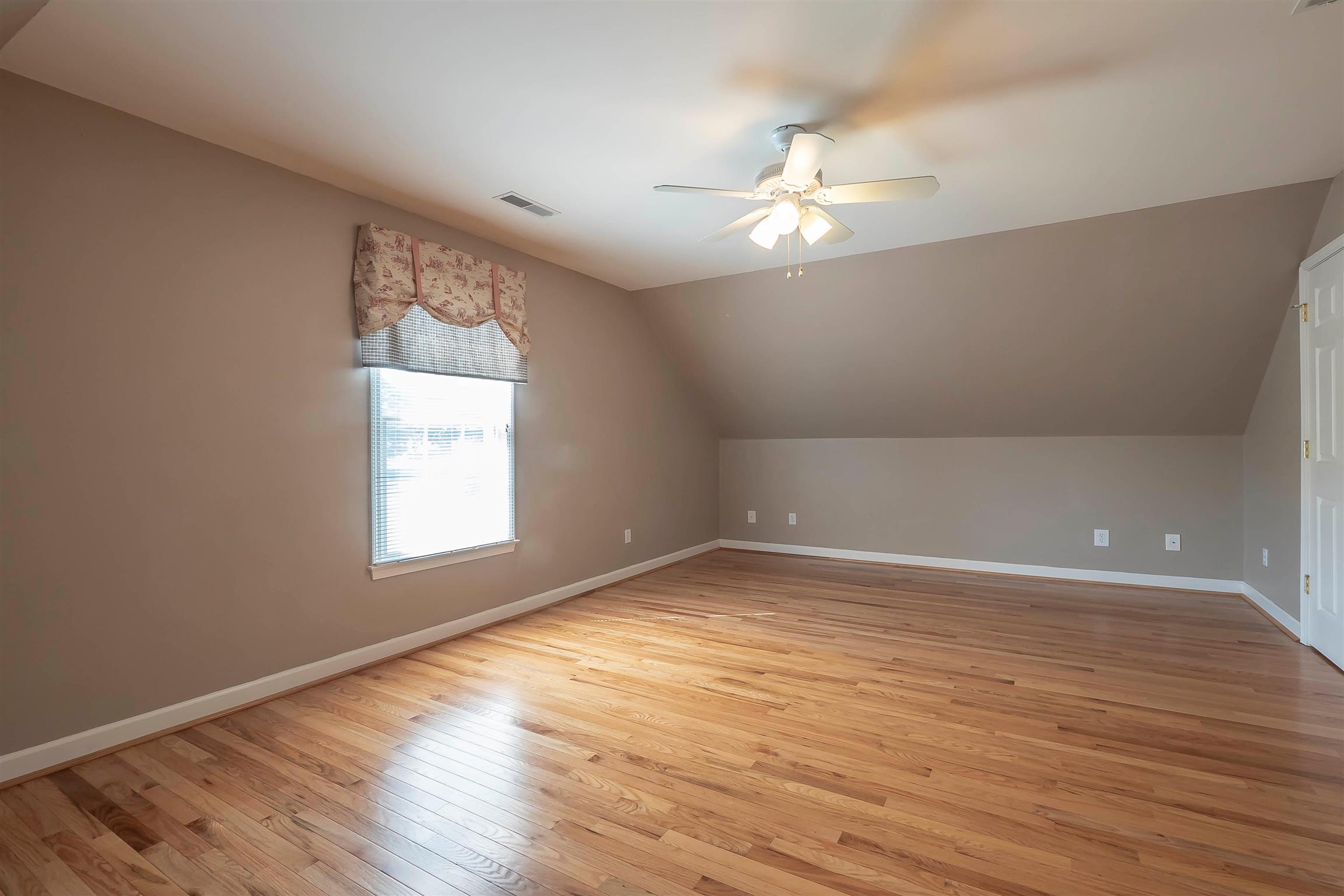 7722 Barnhill Road Primm Springs, TN 38476 - Photo 25 of 30 a view of an empty room with wooden floor and a window