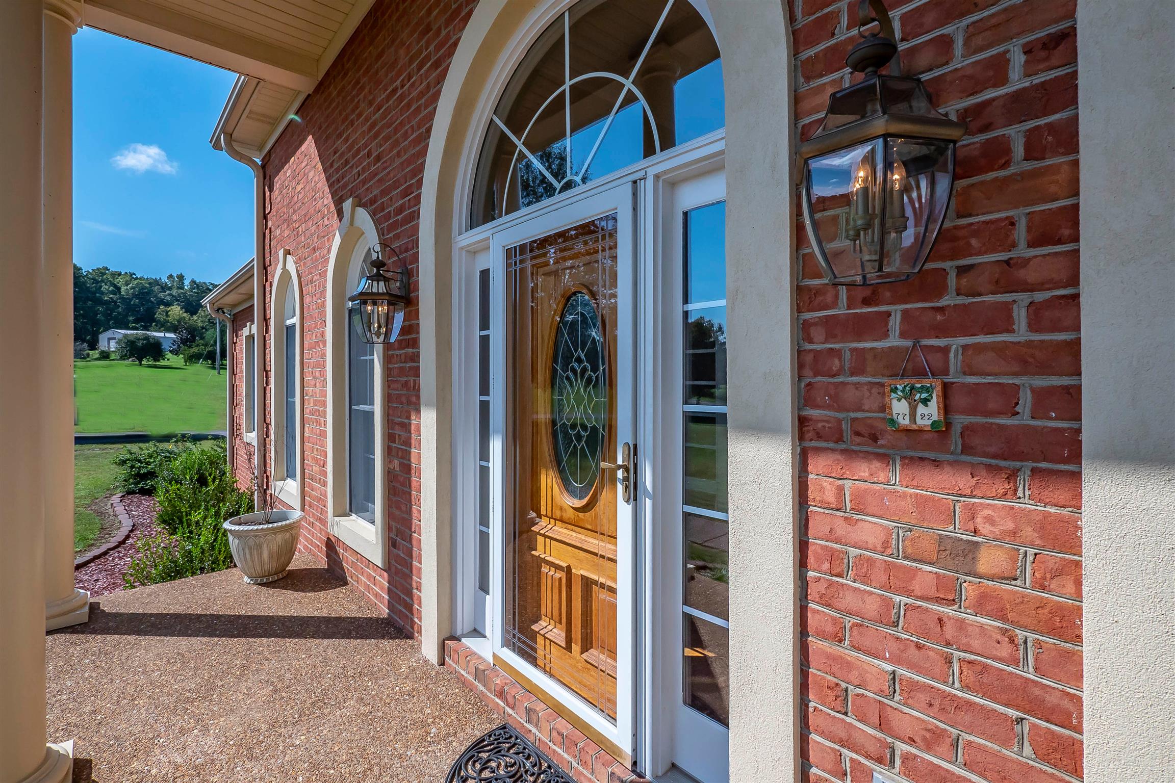 7722 Barnhill Road Primm Springs, TN 38476 - Photo 7 of 30 a view of a door with a potted plant and a window