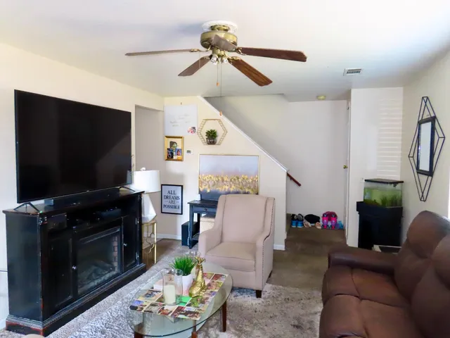 a living room with furniture a fireplace and a flat screen tv
