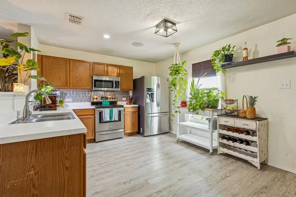 a kitchen with stainless steel appliances a stove cabinets and wooden floor