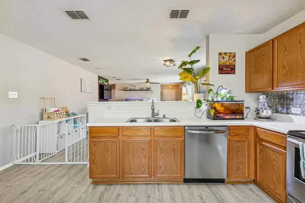 a kitchen with a sink cabinets and wooden floor