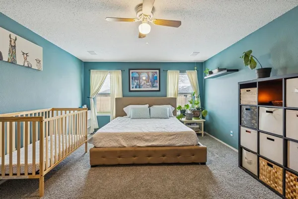 a spacious bedroom with a bed and a flat screen tv