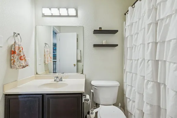 a bathroom with a sink a toilet and shower curtain