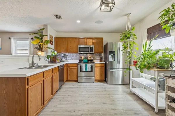 a kitchen with stainless steel appliances a refrigerator sink and cabinets
