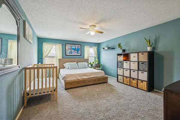 a spacious bedroom with a large bed and a chandelier