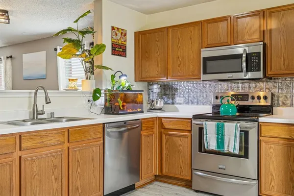 a kitchen with stainless steel appliances granite countertop a sink stove and microwave