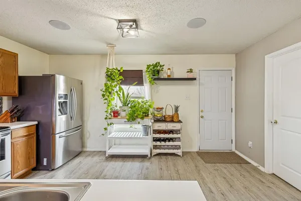 a living room with furniture and a refrigerator