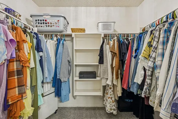 a view of walk in closet with clothes and shoes