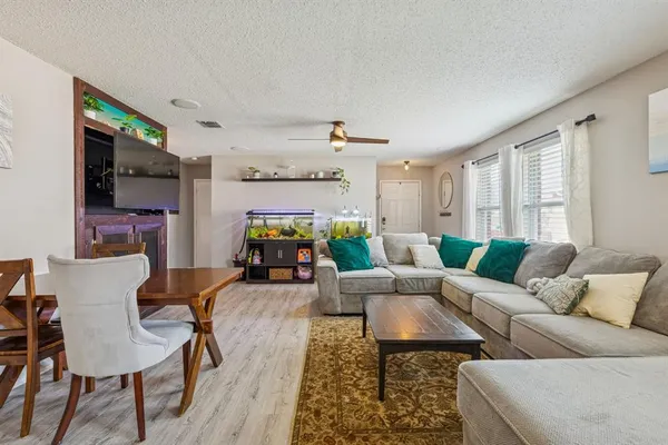 a living room with furniture a flat screen tv and a window