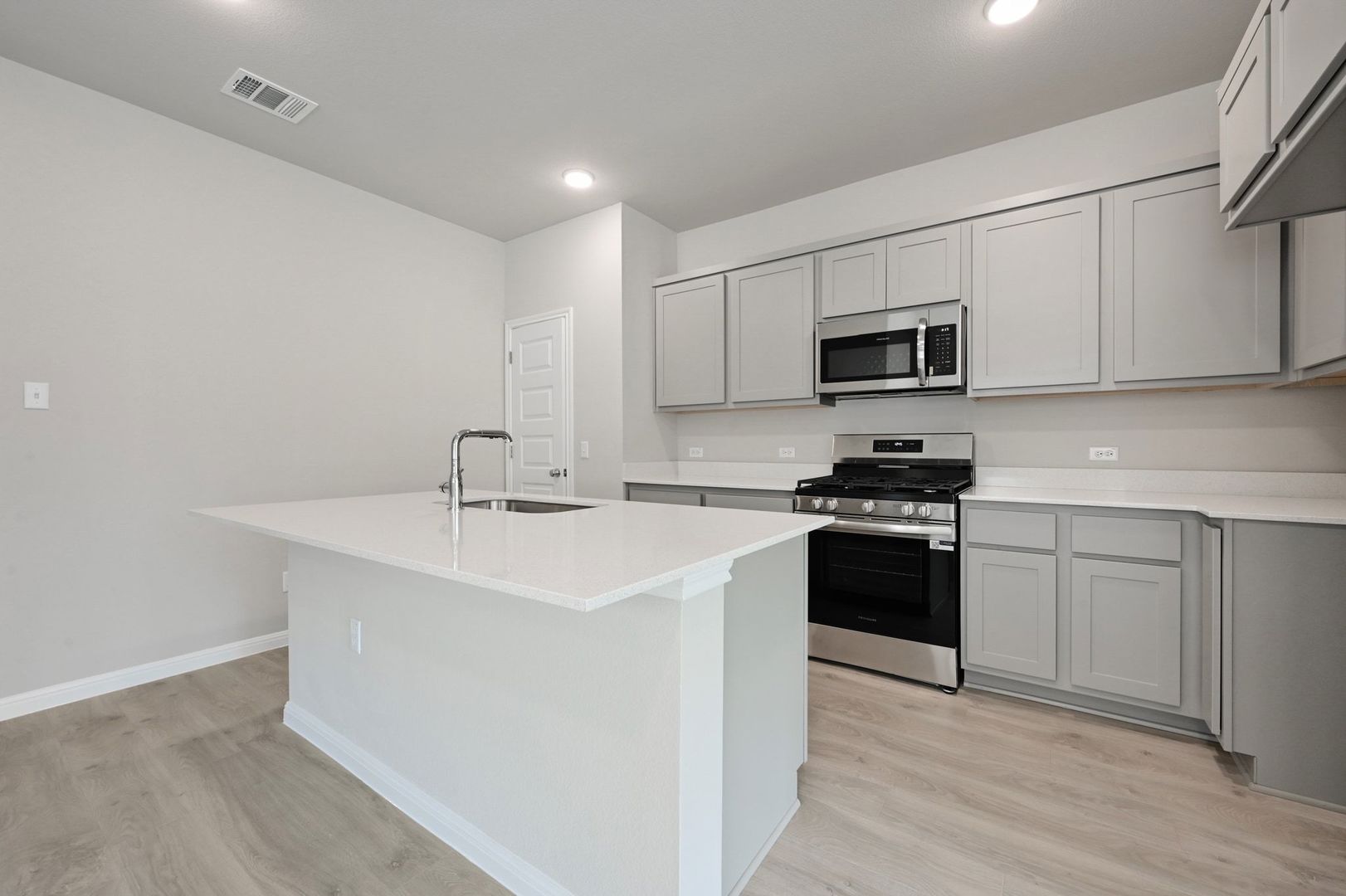 174 Hornet Street Elgin, TX 78621 - Photo 6 of 36 a kitchen with stainless steel appliances a sink stove and microwave
