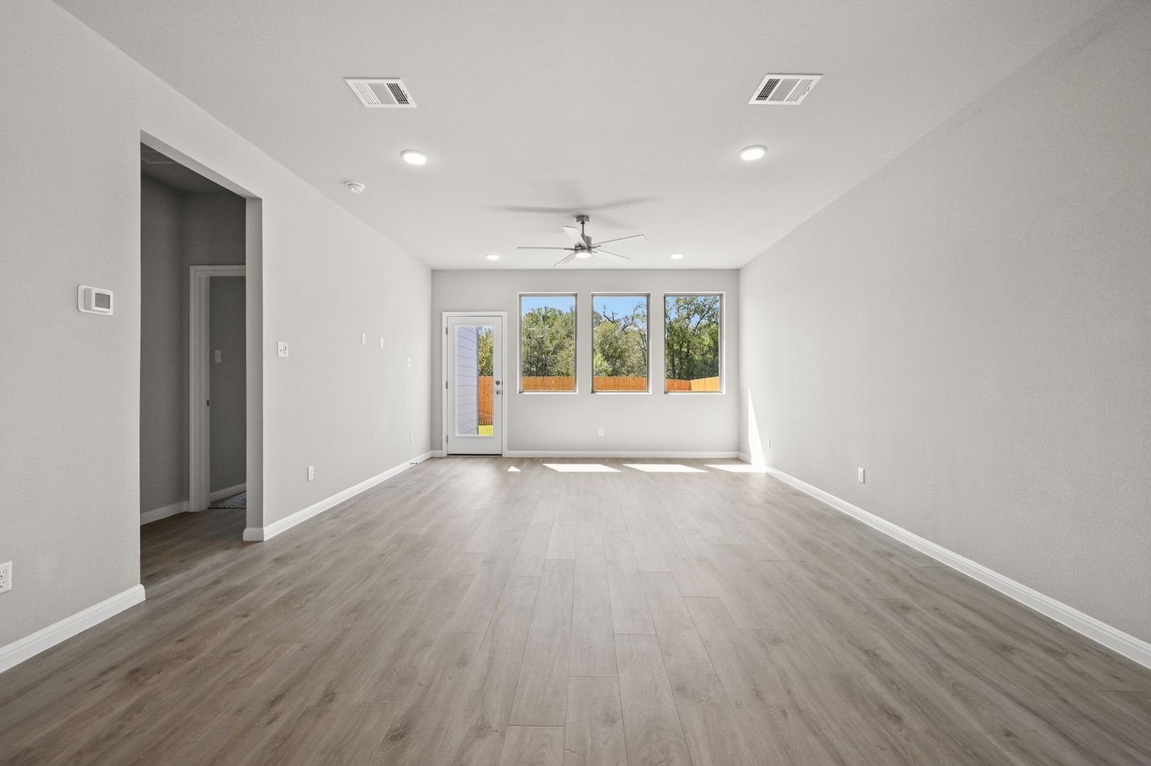 174 Hornet Street Elgin, TX 78621 - Photo 9 of 36 an empty room with wooden floor and a window