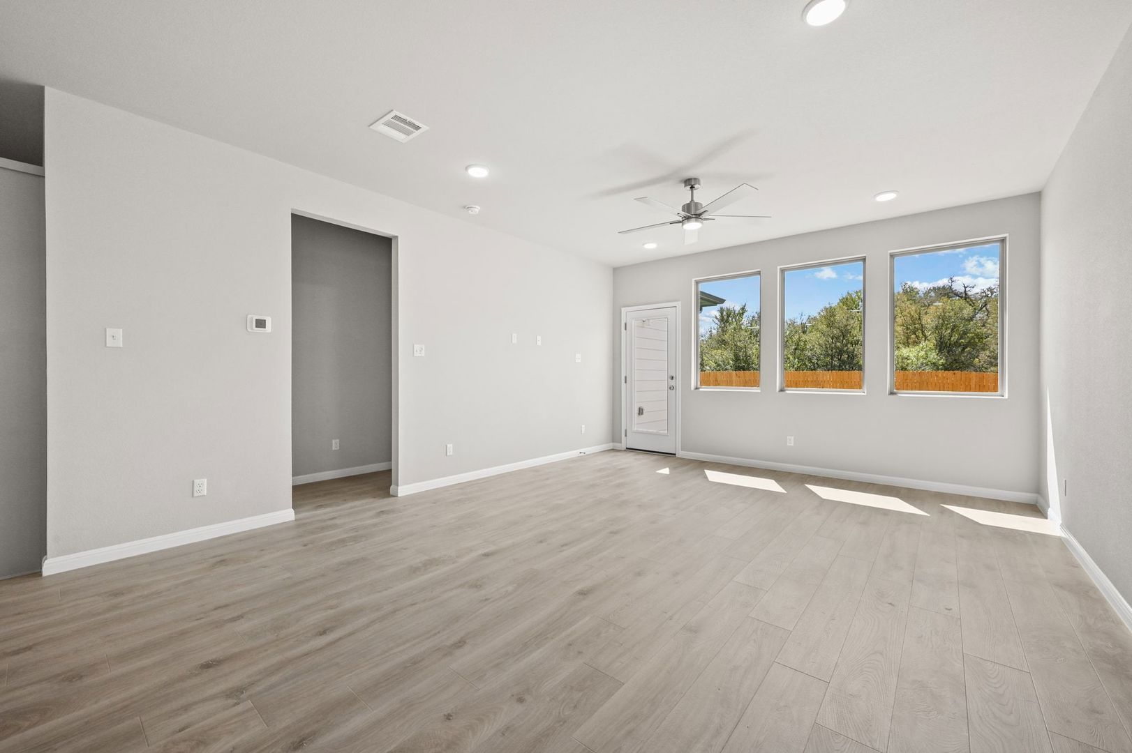 174 Hornet Street Elgin, TX 78621 - Photo 10 of 36 an empty room with wooden floor and windows