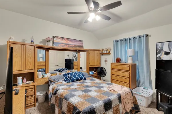 a bedroom with a bed and dresser with mirror