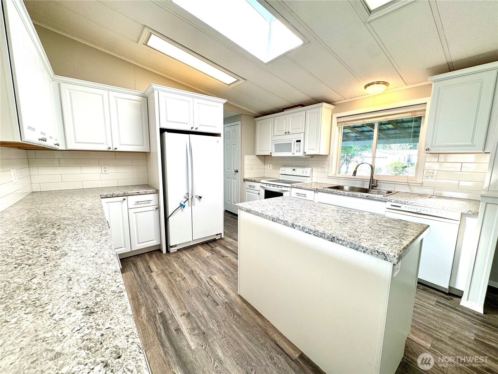 1218 South 3rd Street Dayton, WA 99328 - Photo 10 of 23 a kitchen with stainless steel appliances granite countertop a sink a stove a refrigerator and white cabinets