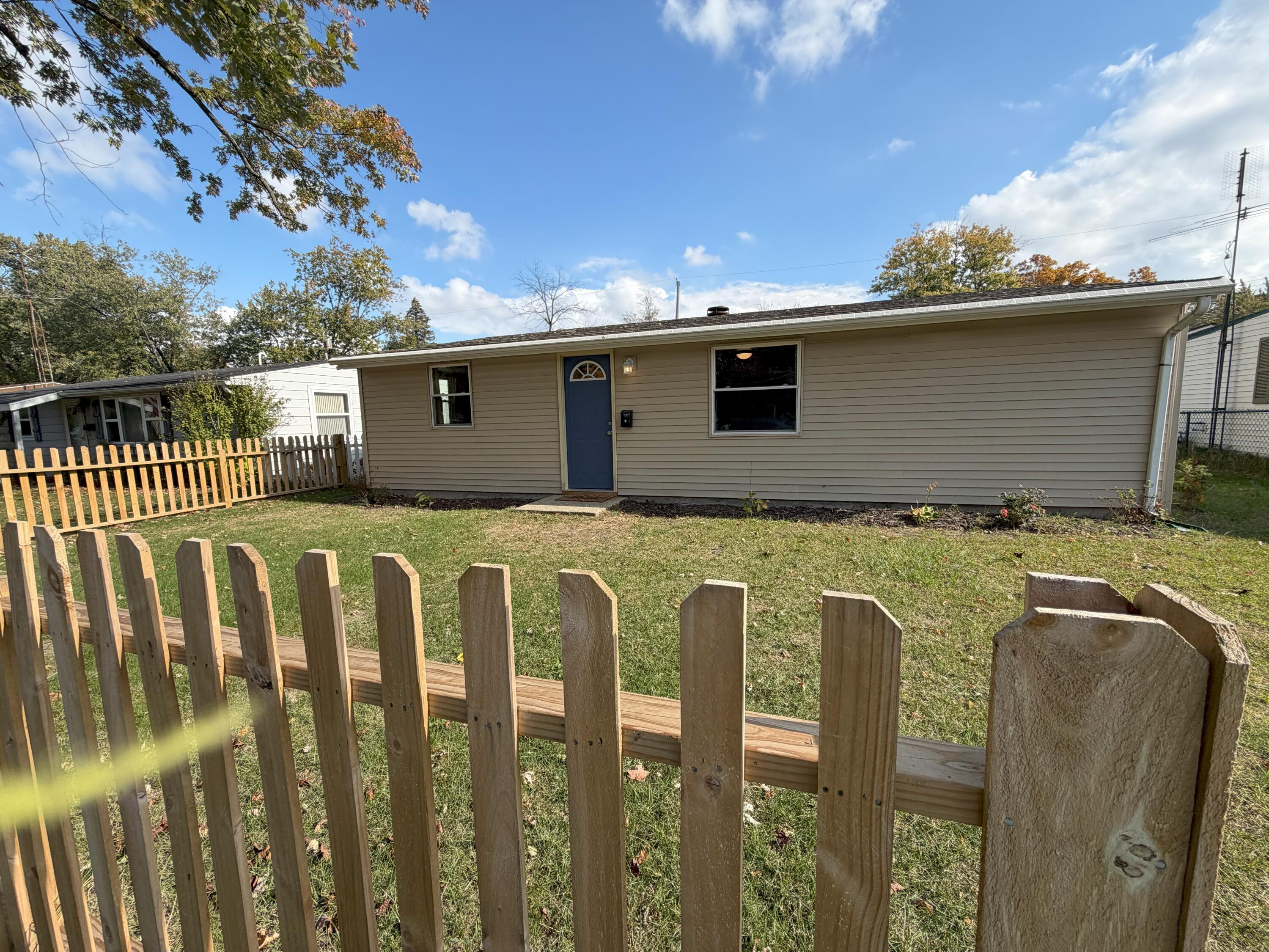 a view of a house with a wooden fence