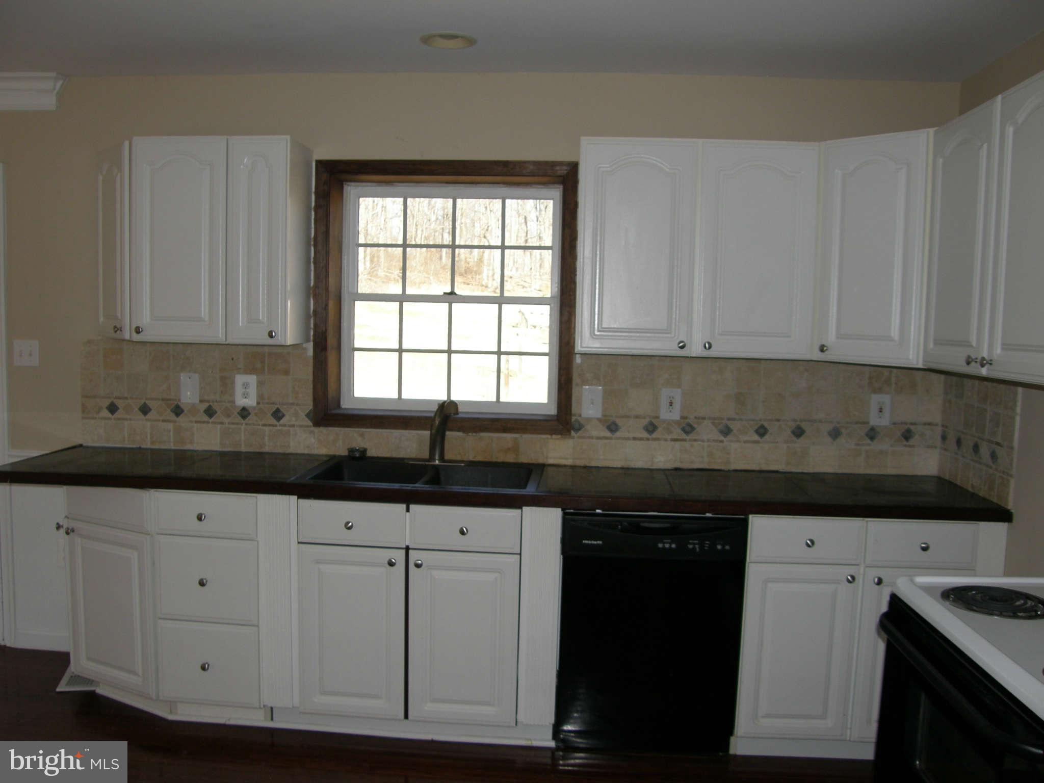 8230 Old Stillhouse Road Rixeyville, VA 22737 - Photo 13 of 30 a kitchen with granite countertop white cabinets and sink
