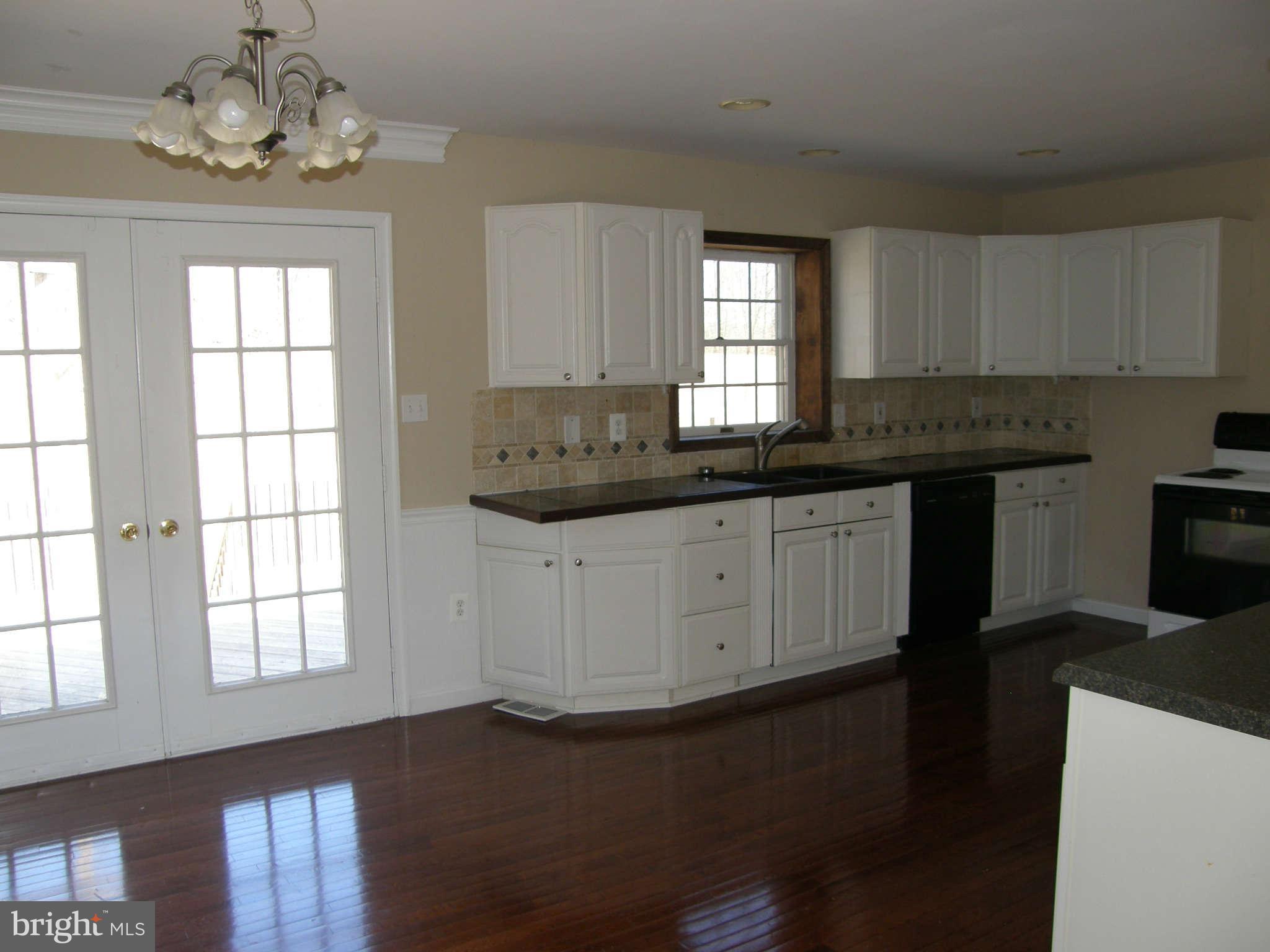 8230 Old Stillhouse Road Rixeyville, VA 22737 - Photo 14 of 30 a kitchen with stainless steel appliances granite countertop a sink a stove cabinets counter space and a window