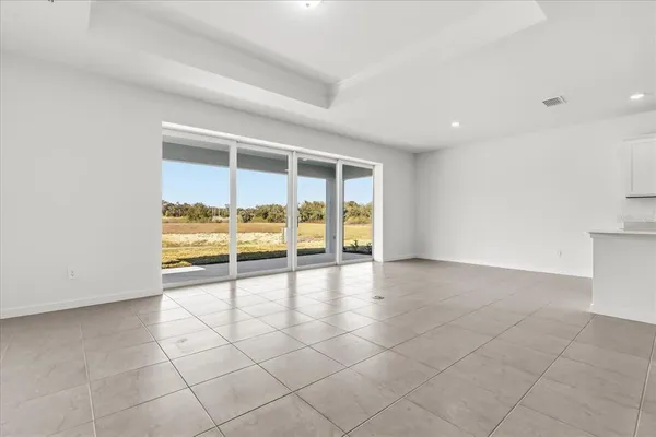 an empty room with floor to ceiling window and an outdoor view