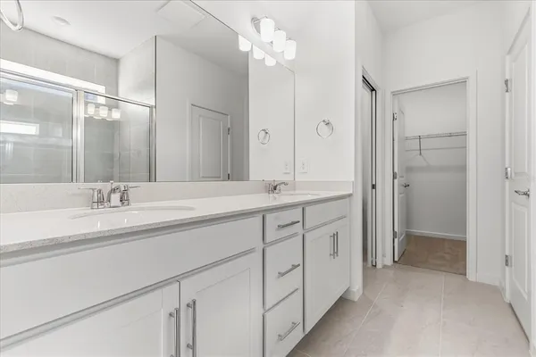 a spacious bathroom with a double vanity sink mirror and shower
