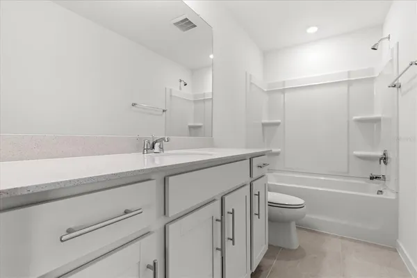 a bathroom with a granite countertop sink a toilet and shower