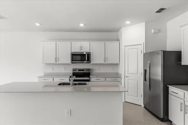 a kitchen with stainless steel appliances a refrigerator and a stove top oven
