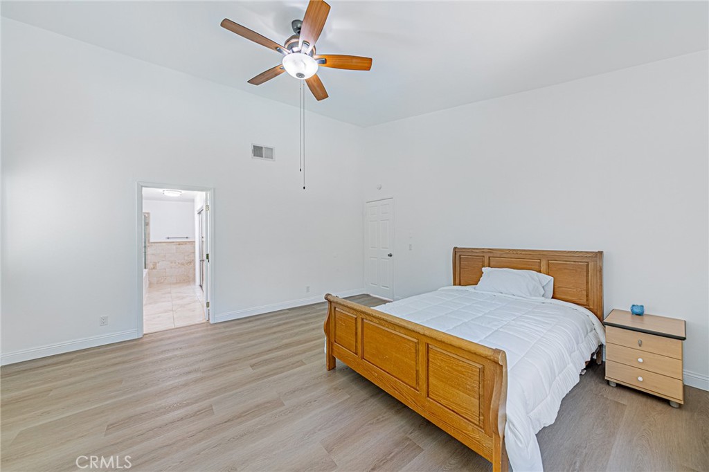 25533 Longfellow Place Stevenson Ranch, CA 91381 - Photo 22 of 47 a bedroom with a bed and wooden floor