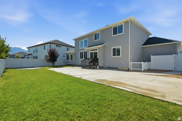 36 West Syracuse Road Vineyard, UT 84059 - Photo 44 of 56 Expansive backyard featuring a manicured lawn, concrete patio, and white vinyl perimeter fencing