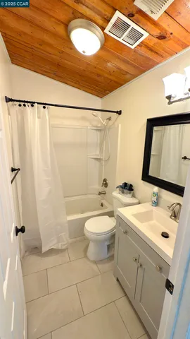 a bathroom with a sink a toilet a mirror and shower