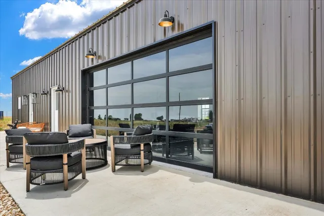 a living room with patio furniture and a floor to ceiling window