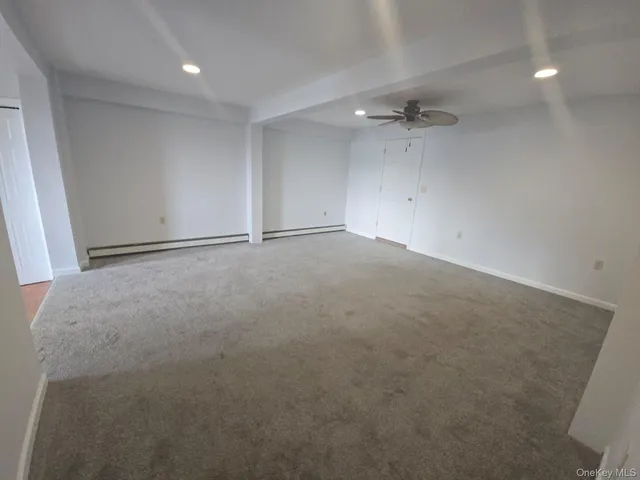 an empty room with an entryway and fan