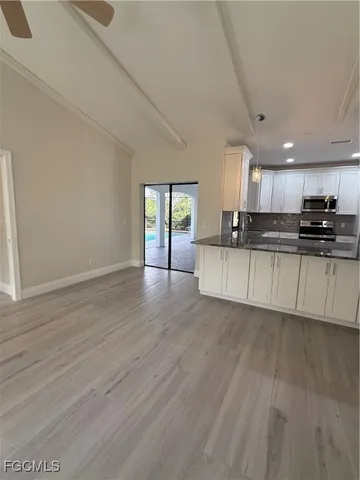 a kitchen with granite countertop a stove and cabinets