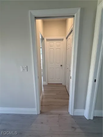 a view of a hallway with wooden floor