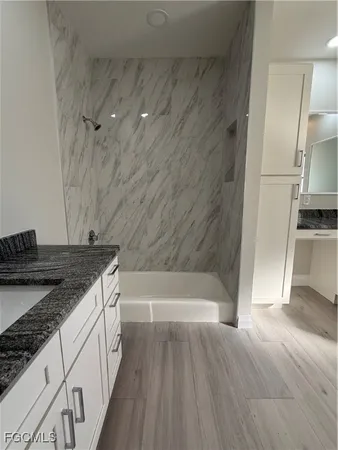 a bathroom with a granite countertop sink toilet and shower