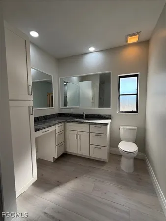 a bathroom with a toilet sink and mirror