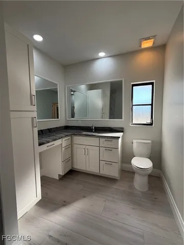 a bathroom with a toilet sink and mirror