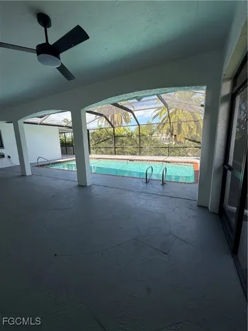 a view of an empty room with a floor to ceiling window and a ceiling fan